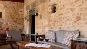 A rustic outdoor seating area with stone walls, a wooden table, and a sofa. - Finca Morro, in a quiet location, views of the mountains, pool, WIFI, A/C (Pollenca)
