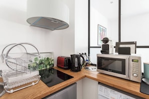 A modern kitchen with a microwave, kettle, and toaster on the counter.