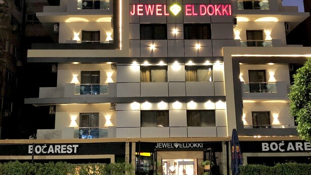 Un edificio de varios pisos con letreros iluminados que dicen 'JEWEL EL DOKKI' y 'BOČAREST'.