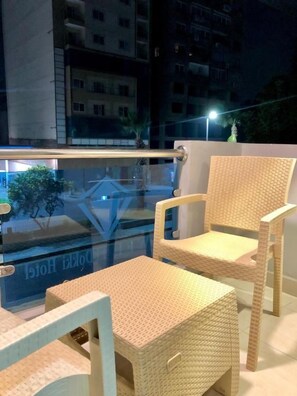 A balcony with wicker furniture, including chairs and a table. - Jewel Dokki Hotel (Giza)