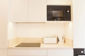 Una cocina equipada con microondas, tostadora y cafetera.