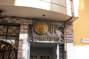 A hotel entrance with a sign reading "Garcilaso Inn" and a decorative emblem above the entrance. - Hospedaje Garcilaso Inn (Cusco)