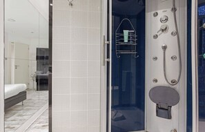 A modern bathroom with a glass-enclosed shower, a towel rack, and a toilet. - The Modern Eiffel 2BDR Stay in Paris Center (Paris)