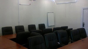 A conference room with a long table and several chairs.
