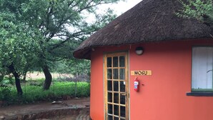 Un petit bâtiment avec un toit de chaume et une enseigne sur laquelle on peut lire « MOSU ».