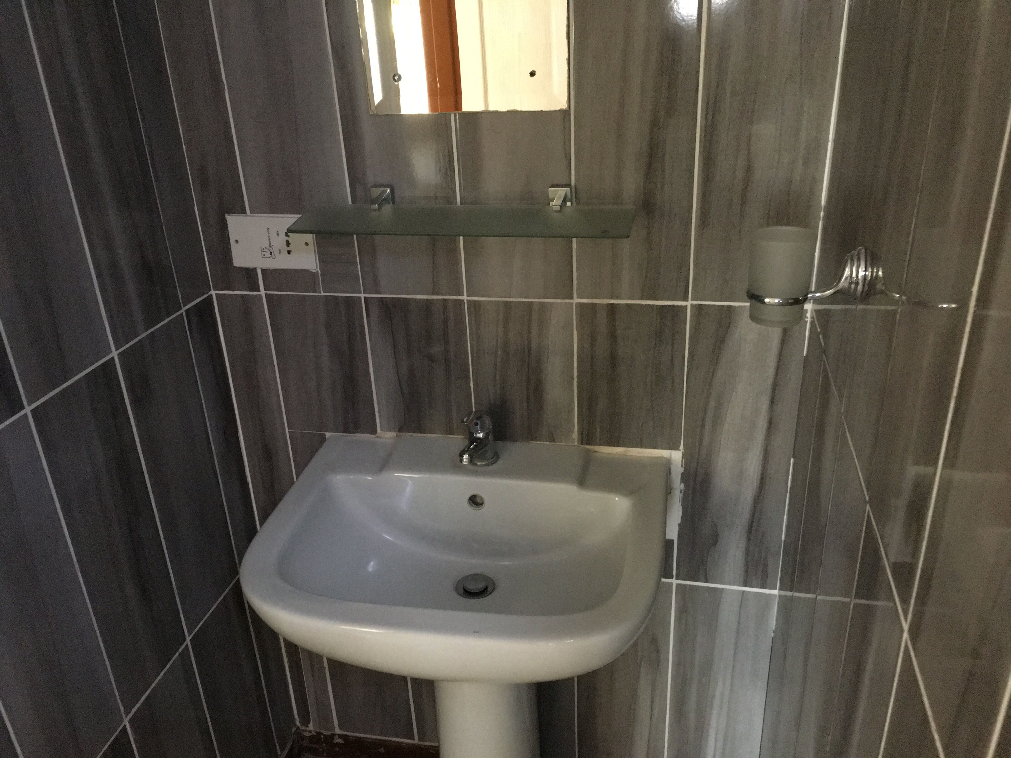 A bathroom with a white sink, a mirror above it, and a towel rack to the right.