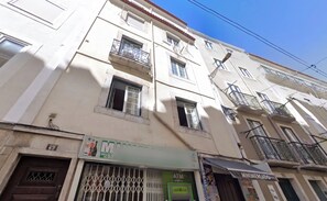 Un immeuble à plusieurs étages dont le rez-de-chaussée est occupé par un commerce.