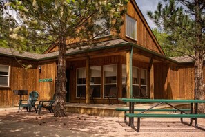 A rustic wooden building with large windows and a covered outdoor seating area. - Mt. Oxford Chalet at Creekside chalets (Salida)