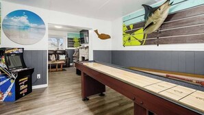 Ein Billardtisch in einem Raum mit Wandgemälde von Fisch und Strandansicht.