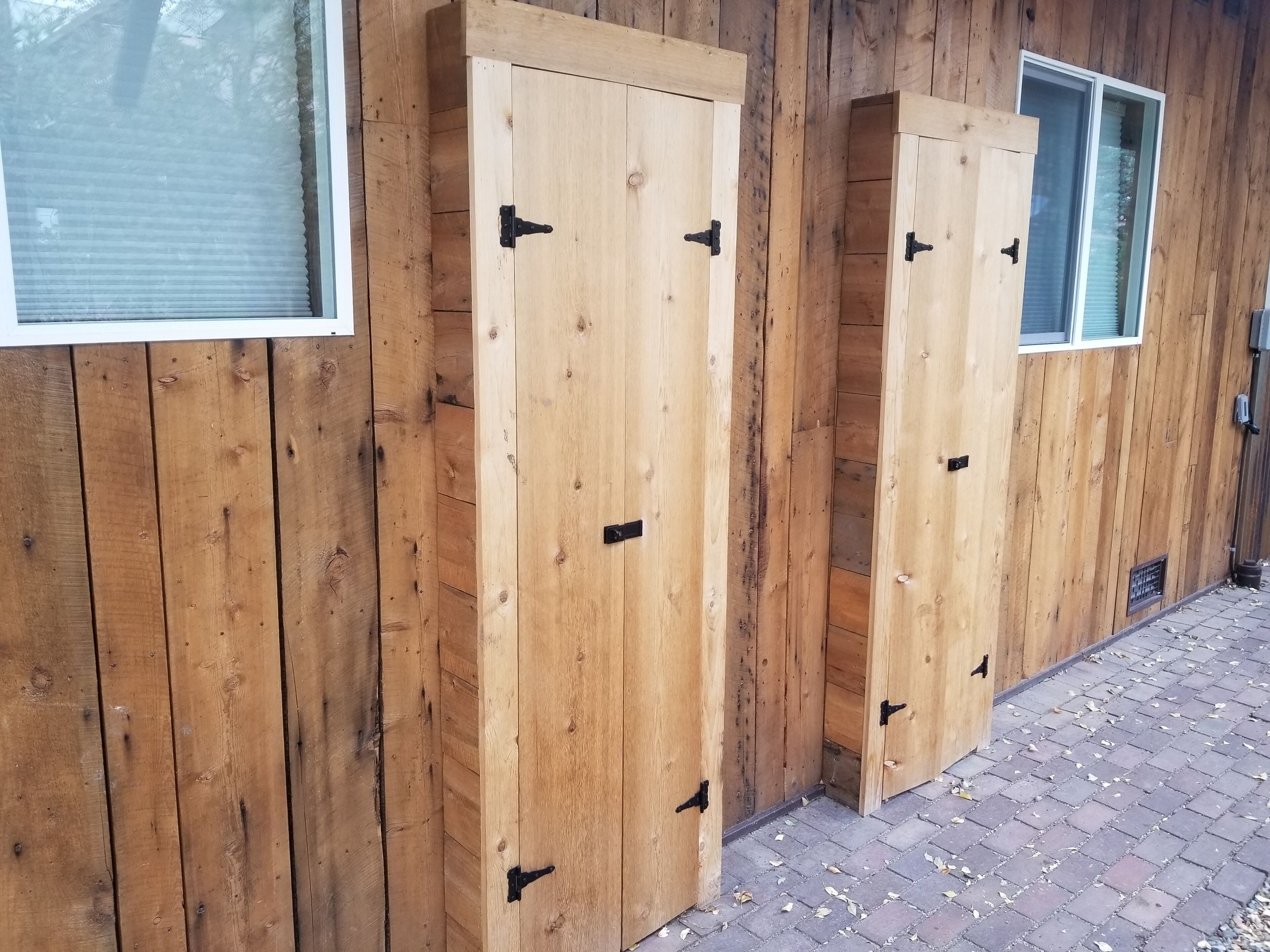 Un bâtiment en bois doté de deux grandes portes et d’une fenêtre.
