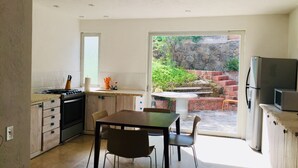 A modern kitchen with a dining area, a refrigerator, and a stove. - Nice Cozy Apartment in Juriquilla (Qro.)