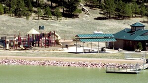 A park with playground equipment, a covered pavilion, and a building with a green roof. - Spacious and Comfortable Garden Level Basement Apartment (Peyton)