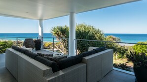 A covered outdoor seating area with a view of the ocean. - Sunshine Coast White House (Castaways Beach)