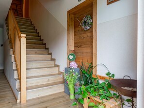 A wooden staircase leading to a door with a wreath and a welcome sign. - Spacious apartment with a balcony (Wagrain)