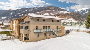 Un edificio de varios pisos con techo nevado, una escalera y un balcón.