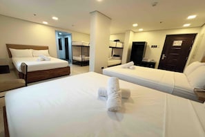 A hotel room with two single beds, a wooden headboard, and a bunk bed. - Belltower Csheli Suites Bantay - Vigan By Zuzu (Bantay)