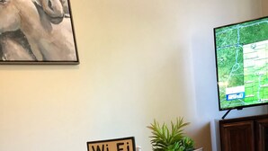 A wooden table with a sign reading "Wi-Fi" and a small plant on it.