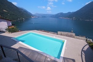 Una piscina al aire libre de temporada, sillones reclinables de piscina