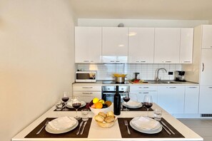 Departamento familiar, 2 habitaciones, microondas, junto a la montaña (Residence degli Oleandri 4B) | Cocina privada | Cafetera y tetera, refrigerador con congelador, microondas y horno 