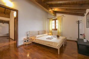 Een slaapkamer met een houten bed, nachtkastje, gordijnen en een radiator.