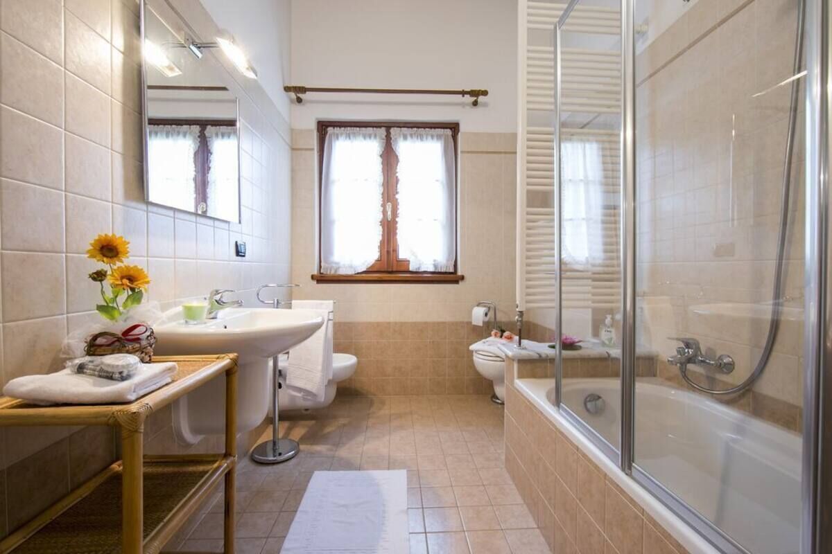 A bathroom with a sink, mirror, toilet, and shower.