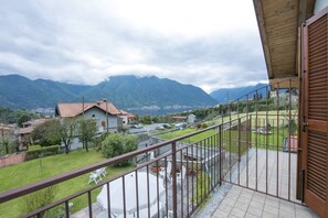 Een balkon met uitzicht op bergen en een stad.