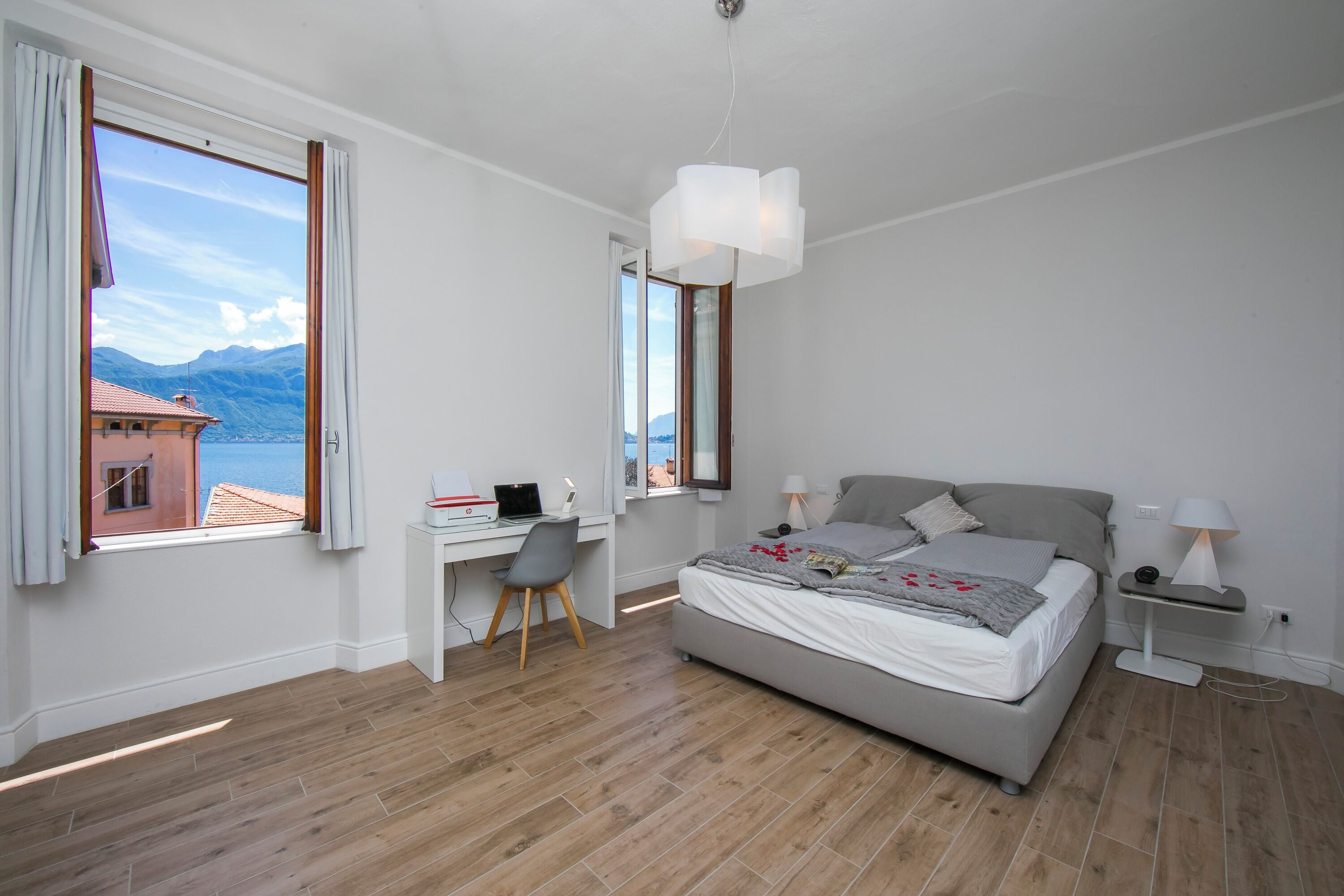 Una camera da letto con un letto, una scrivania, una sedia e vista sulle montagne attraverso una finestra.