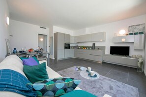 A modern living room with a sofa, coffee table, and a TV in the background. - Sant' Agata Bellavista (Tremezzina)