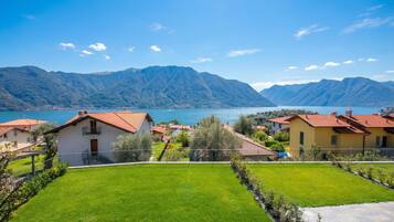A residential area with houses, a well-maintained lawn, and mountains in the background.