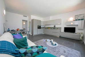 A modern living room with a sofa, coffee table, and a TV in the background. - Sant' Agata Bellavista (Tremezzina)