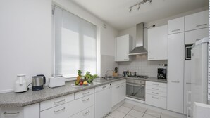 A modern kitchen with white cabinets, a granite countertop, and a stainless steel range hood. - Residence Romina Lakeview Apt. (San Siro)