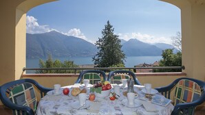 A table set for breakfast with a scenic mountain view. - Residence Romina Lakeview Apt. (San Siro)