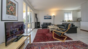 A modern living room with a flat-screen TV, leather sofas, a coffee table, and a red patterned rug. - Residence Romina Lakeview Apt. (San Siro)