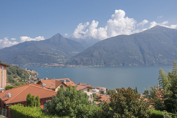 A mountainous landscape with a lake and buildings in the foreground.