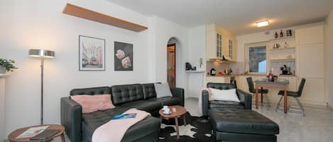 Un salon moderne comprenant un canapé, une table basse et un coin repas avec des chaises et une table.
