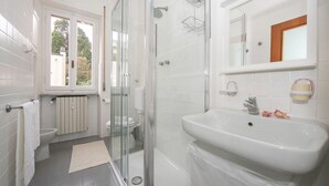 A modern bathroom with a glass-enclosed shower, a white sink, and a toilet. - La Casa del Vitt (Menaggio)