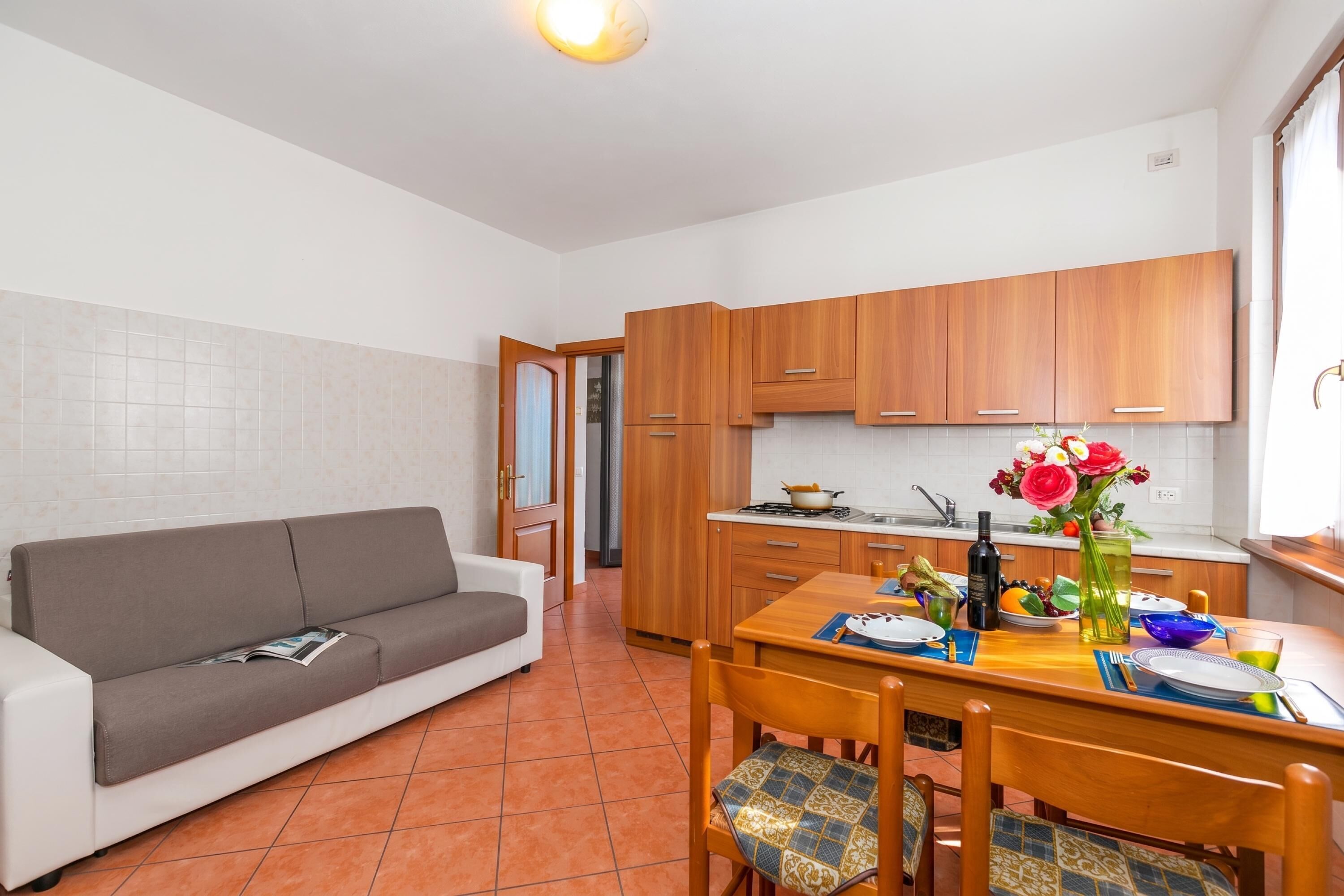 A compact living space with a kitchenette, a dining area, and a sofa.