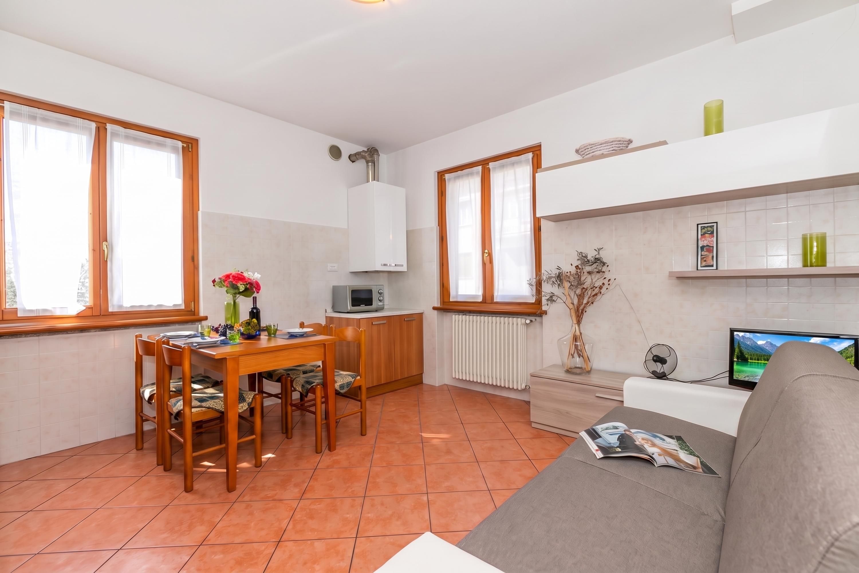 A compact living space with a dining area, kitchenette, and seating area.