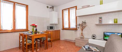 A compact living space with a dining area, kitchenette, and seating area.