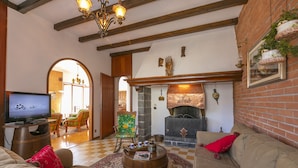 Una sala de estar acogedora con chimenea, televisor y asientos cómodos.