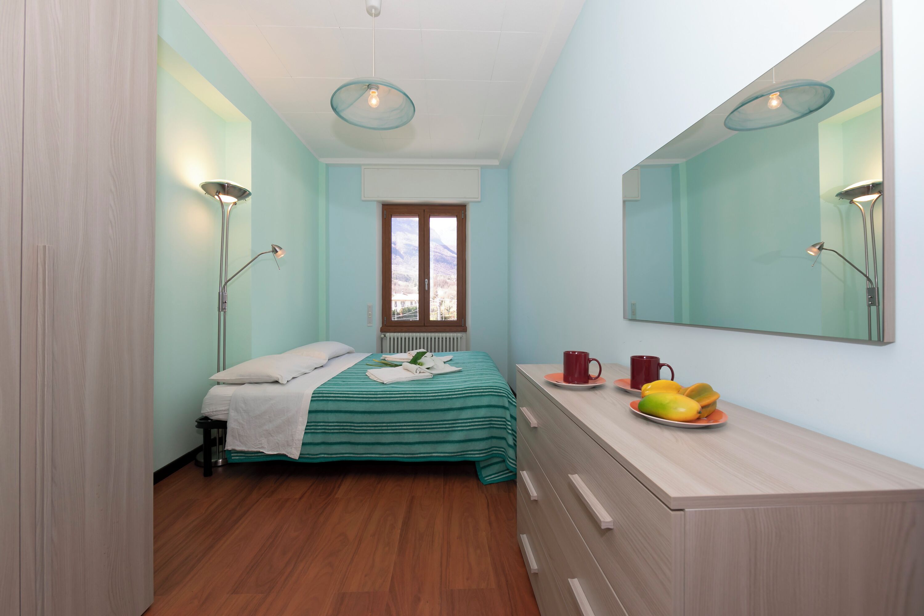 Ein Schlafzimmer mit Bett, Nachttisch und Spiegel.