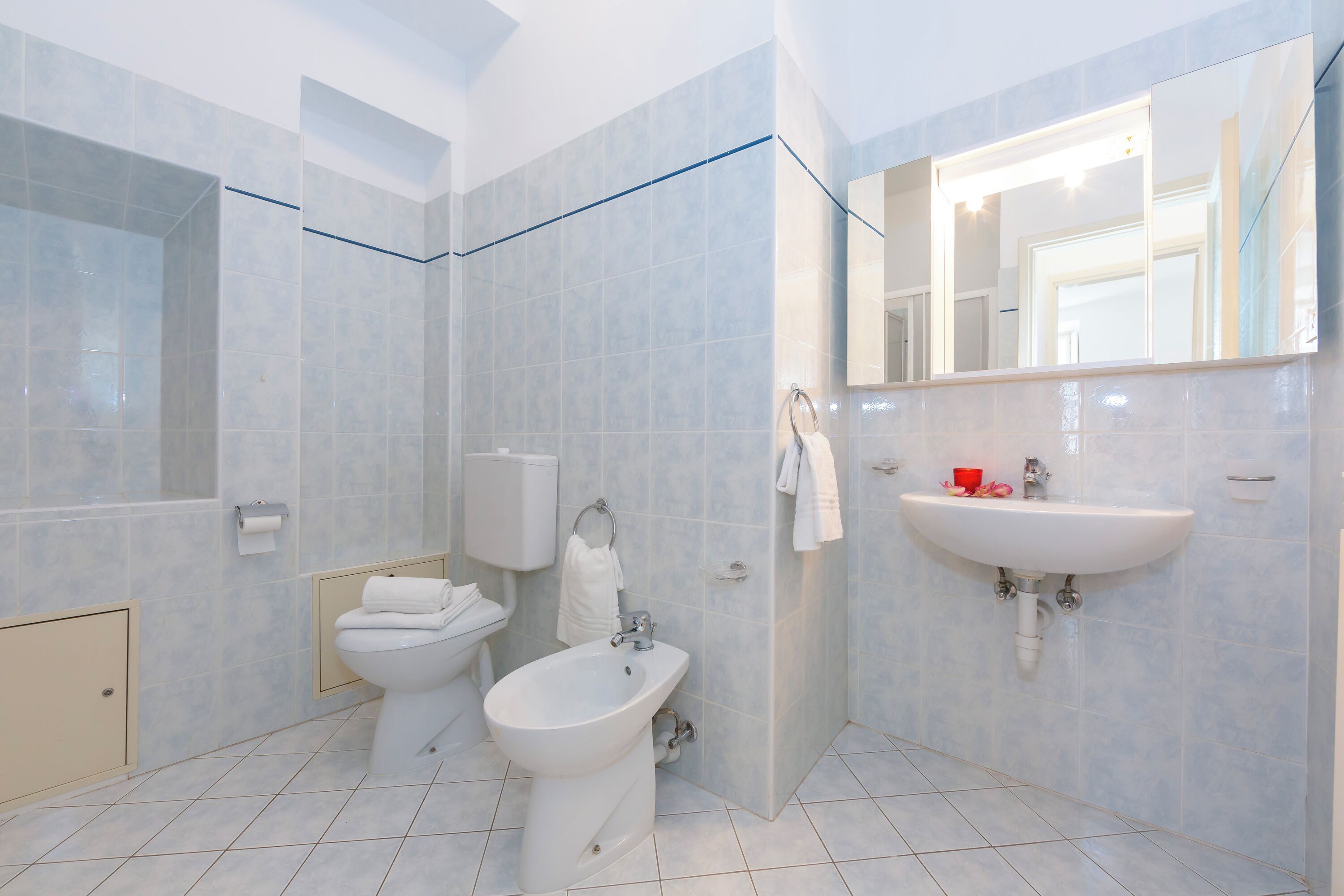 A modern bathroom with a toilet, bidet, and sink.