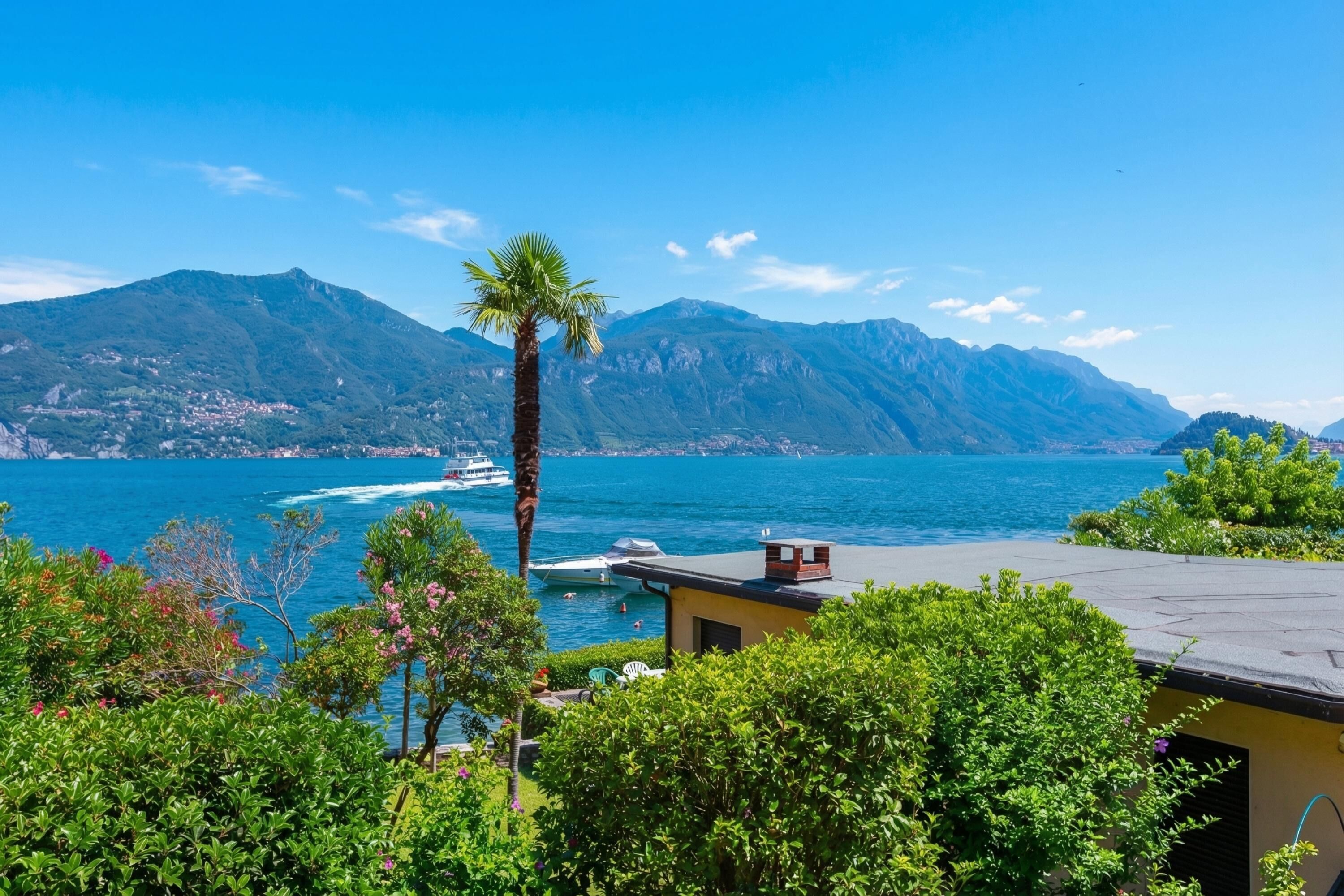 A coastal view with mountains, a palm tree, and a boat on the water.