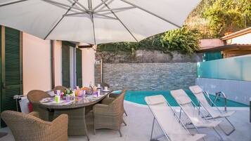 Una piscina al aire libre de temporada, sillones reclinables de piscina