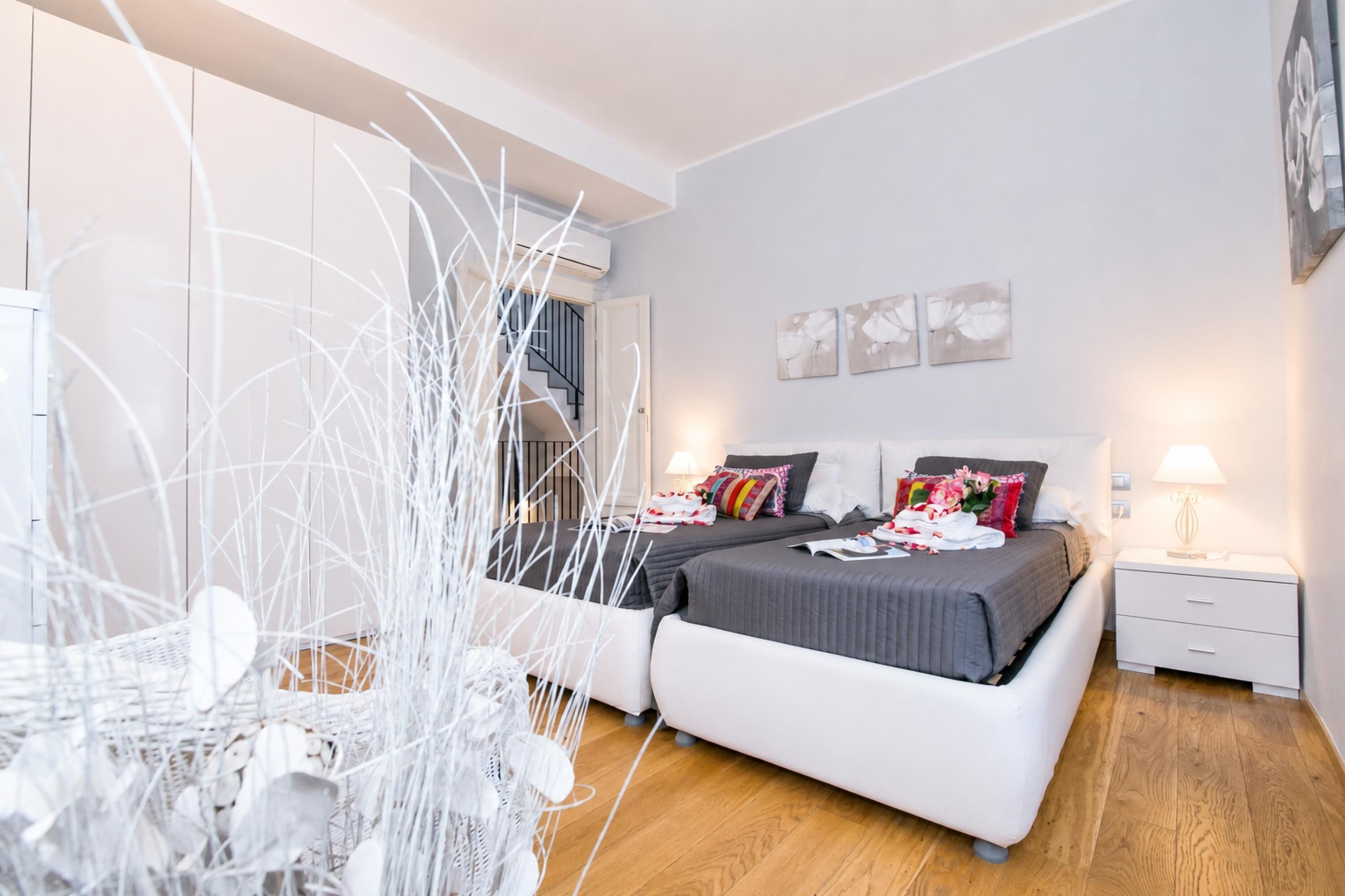 A modern bedroom with a large bed, bedside tables, and a view of the outside.