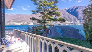 A balcony with a view of a lake, mountains, and a small tent-like structure. - Villa Lucia Laglio (Laglio)
