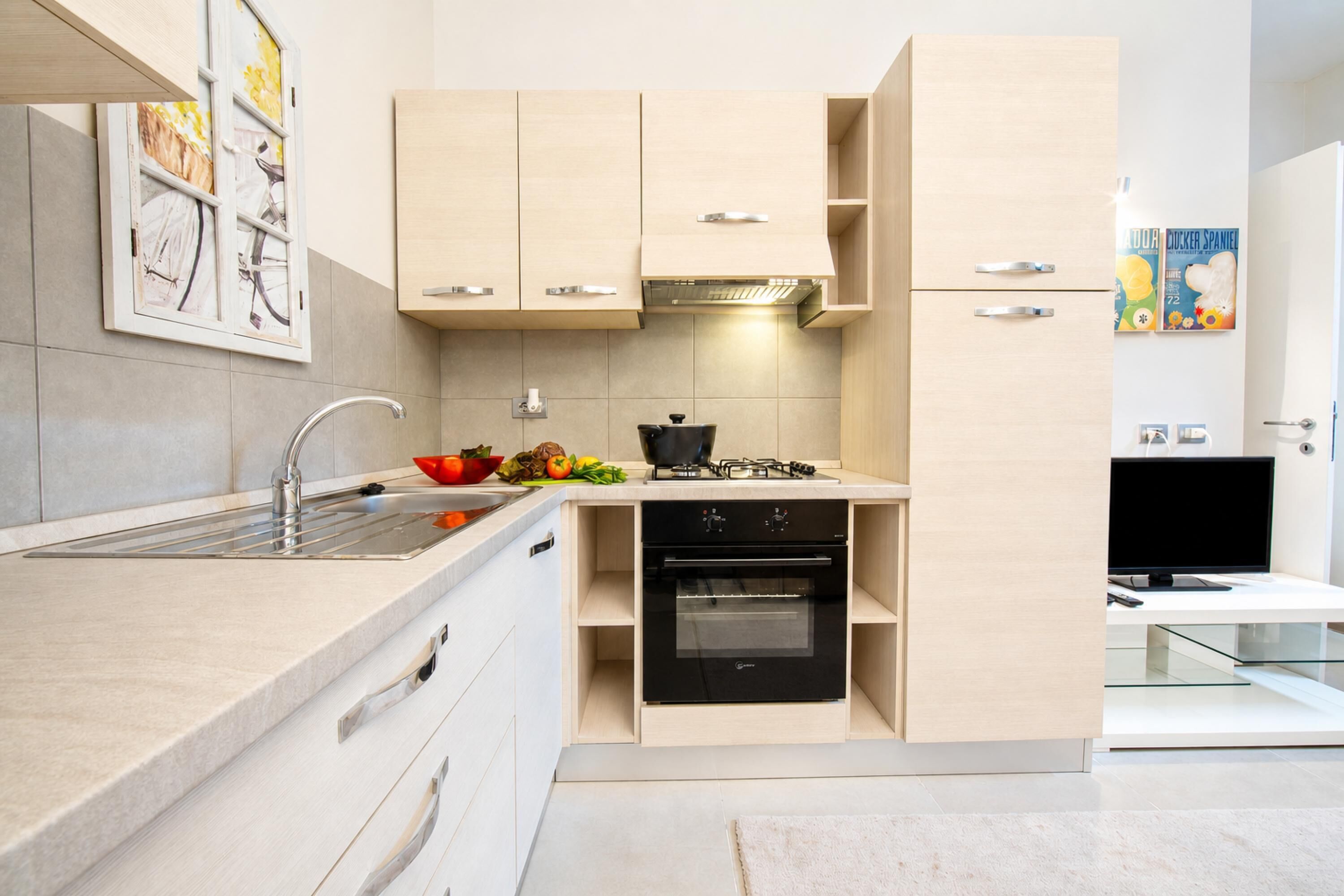 Een moderne keuken met een inbouwoven, een spoelbak en een kookplaat.
