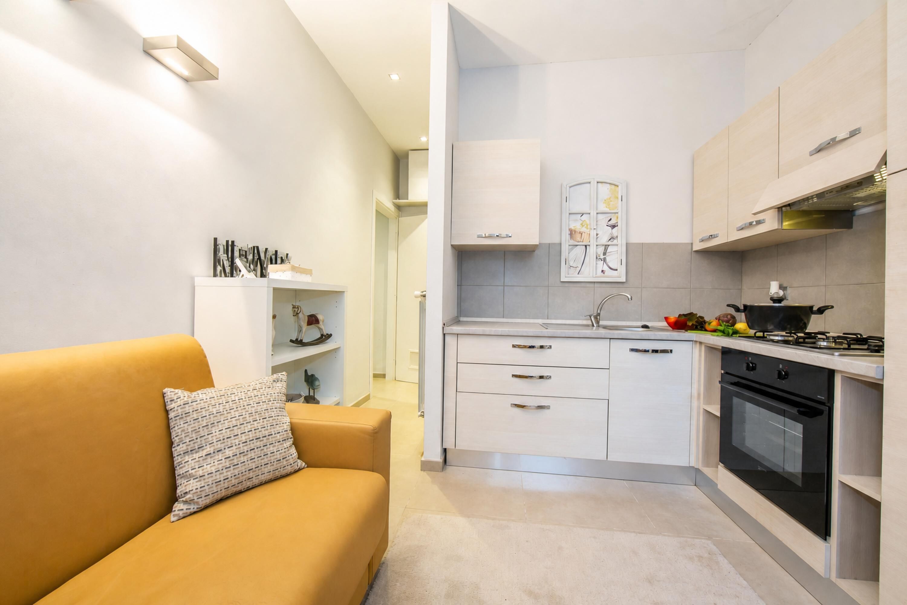 A modern kitchen with white cabinets, a built-in oven, and a gas stove.