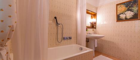 Un baño con bañera, ducha y lavabo.