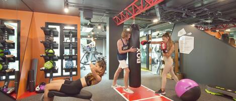 A gym with exercise equipment, a punching bag, and a treadmill.